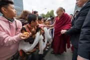 По прибытии на стадион Халлен Его Святейшество Далай-лама приветствует юных тибетцев. Цюрих, Швейцария. 23 сентября 2018 г. Фото: Мануэль Бауэр.