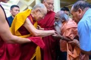 По дороге из главного тибетского храма в свою резиденцию Его Святейшество Далай-лама приветствует пожилого мужчину. Дхарамсала, Индия. 10 мая 2019 г. Фото: Тензин Чойджор.