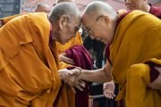 Поднявшись на сцену на площадке Калачакры, Его Святейшество Далай-лама приветствует бывшего держателя трона Ганден Ризонга Ринпоче. Бодхгая, штат Бихар, Индия. 2 января 2020 г. Фото: Тензин Чойджор.