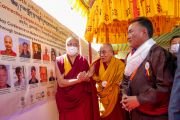 Его Святейшество Далай-лама проходит мимо баннера с фотографиями докладчиков двухдневной конференции, организованной в рамках золотого юбилея сообщества «Ламдон» и открытия Великих летних диспутов (Ярчо ченмо) – 2023. Ле, Ладак, Индия. 7 августа 2023 г. Фото: Тензин Чойджор (офис ЕСДЛ).
