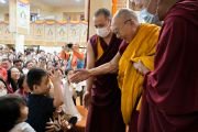 Покидая главный тибетский храм по завершении первого дня учений, организованных по просьбе буддистов из Юго-Восточной Азии, Его Святейшество Далай-лама хочет пожать руку юному слушателю. Дхарамсала, штат Химачал-Прадеш, Индия. 5 сентября 2023 г. Фото: дост. Замлинг Норбу (офис ЕСДЛ).