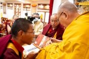 Его Святейшество Далай-лама представляет собравшимся новую книгу по истории монастыря Намгьял. Дхарамсала, штат Химачал-Прадеш, Индия. 14 февраля 2024 г. Фото: дост. Тензин Джампхел (офис ЕСДЛ).