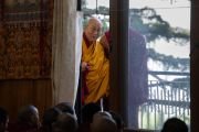 Проходя по веранде по пути в главный тибетский храм, Его Святейшество Далай-лама смотрит на слушателей, собравшихся в храме Калачакры. Дхарамсала, штат Химачал-Прадеш, Индия. 4 июня 2024 г. Фото: Тензин Чойджор (офис ЕСДЛ).