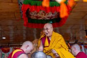 Его Святейшество Далай-лама улыбается собравшимся, занимая свое место в храме Калачакры на площадке для учений в Падуме в начале молебна о долголетии, организованного жителями Занскара. Занскар, Ладак, Индия. 23 июля 2025 г. Фото: Тензин Чойджор