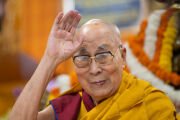 Его Святейшество Далай-лама машет присутствующим во время церемонии подношения молебна о долголетии в главном тибетском храме. Дхарамсала, Химачал-Прадеш, Индия. 8 октября 2025 г. Фото: Тензин Чойджор