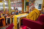 Его Святейшество Далай-лама смотрит на представителей организаторов, проходящих мимо него с подношениями в руках во время молебна о долголетии в главном тибетском храме. Дхарамсала, штат Химачал-Прадеш, Индия. 25 марта 2026 г. Фото: Тензин Чойджор