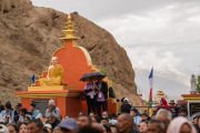 Участники встречи укрываются под зонтиком от легкого дождя во время визита Его Святейшества Далай-ламы к комплексу «1000 статуй Будды» в Международном центре медитации «Махабодхи». Лех, Ладак, Индия. 9 августа 2026 г. Фото: Тензин Чойджор